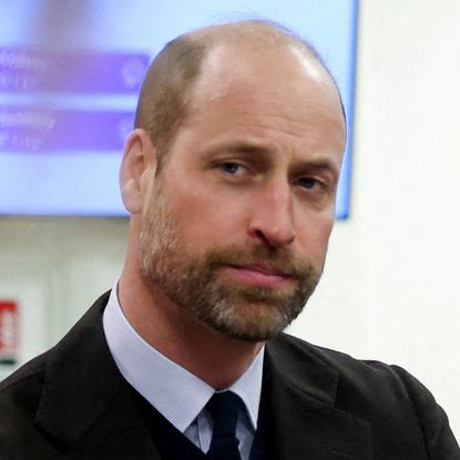 Prince William looks serious while wearing a shirt and tie, he has a beard and a balding hairline