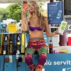 Courtney Grow wearing a purple bikini top with beach pants. 