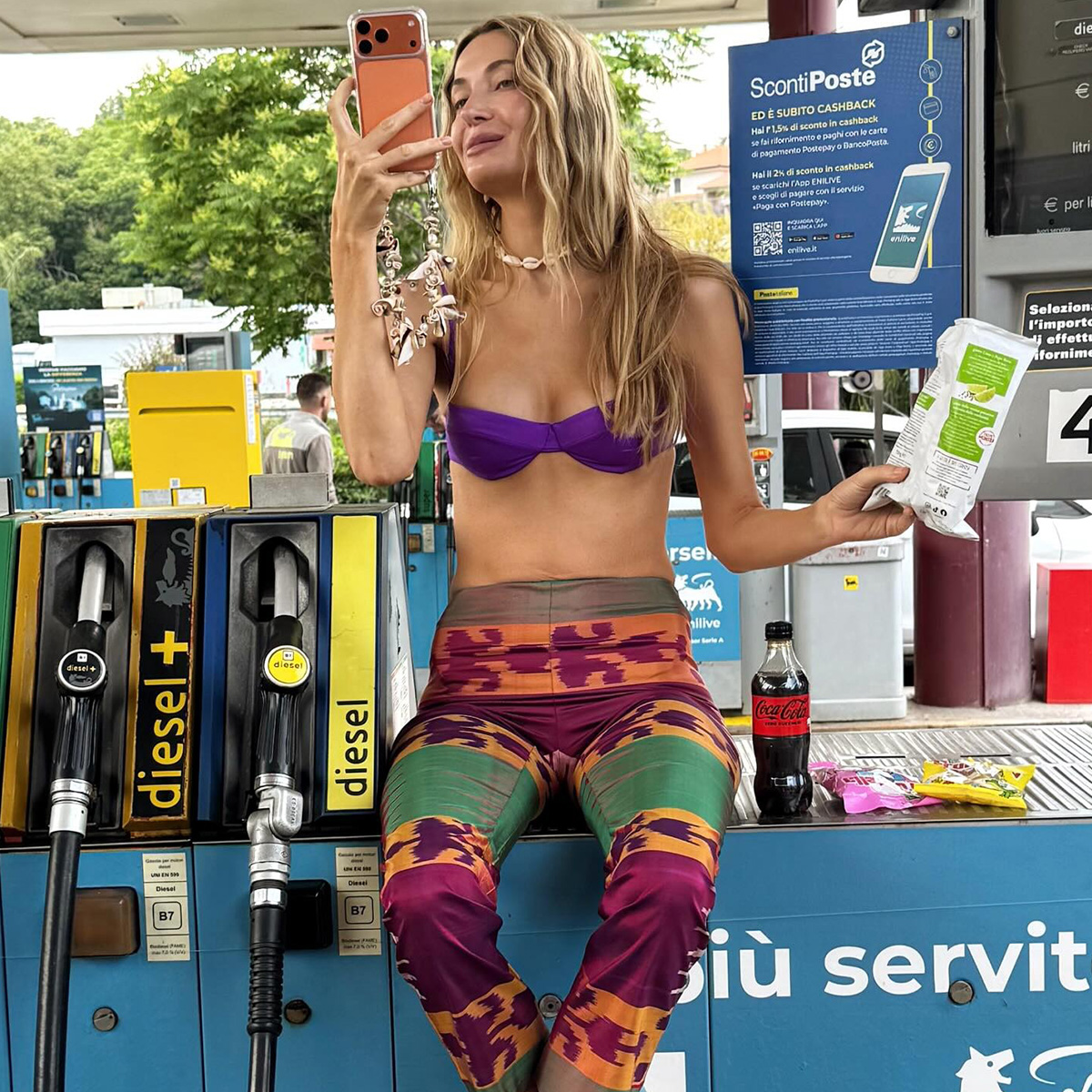 Courtney Grow wearing a purple bikini top with beach pants. 