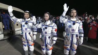 China's Senzhou 13 commander Zhai Zhigang (left) and astronauts Wang Yagping (center) and Ye Guangfu wave to onlookers as they walk out of their crew quarters ahead of their planned launch from the from Jiuquan Satellite Launch Center on Oct. 16, 2021.