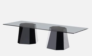 'Cristall' table by Victoria Wilmotte for Coedition. A rectangular table with a glass top on two black cylinders.