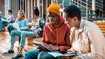 A couple of happy college students look at a laptop together. 