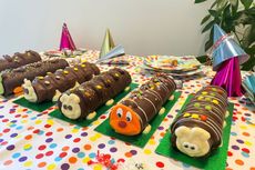 Supermarket caterpillar cakes lined up on a table decorated for a kids birthday party