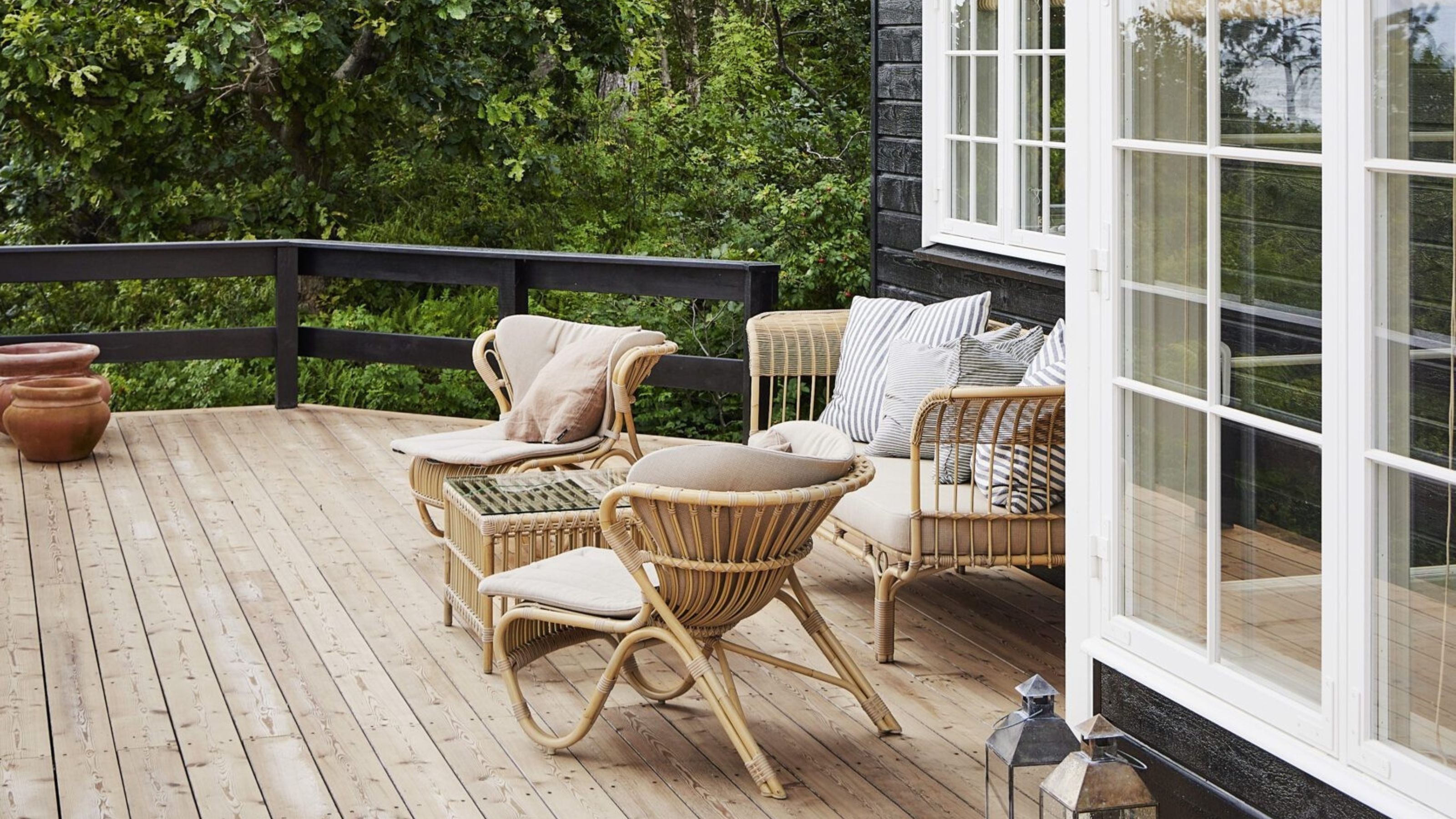 scandinavian coastal style patio with rattan chairs, timber deck, french-style doors