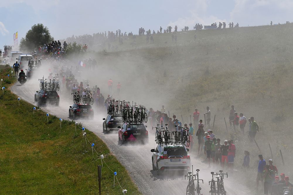 The Tour de France caravan kicks up dust during stage 10