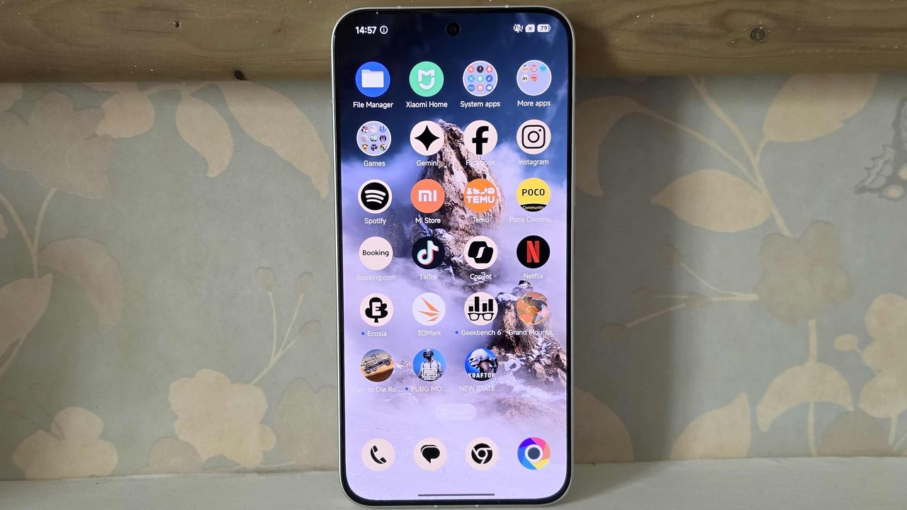 The Poco X8 Pro Max's side menu, showing an apps list, while the phone is leant on a wall.