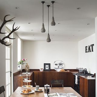 kitchen room with brown wooden cabinets and white ceiling lamps