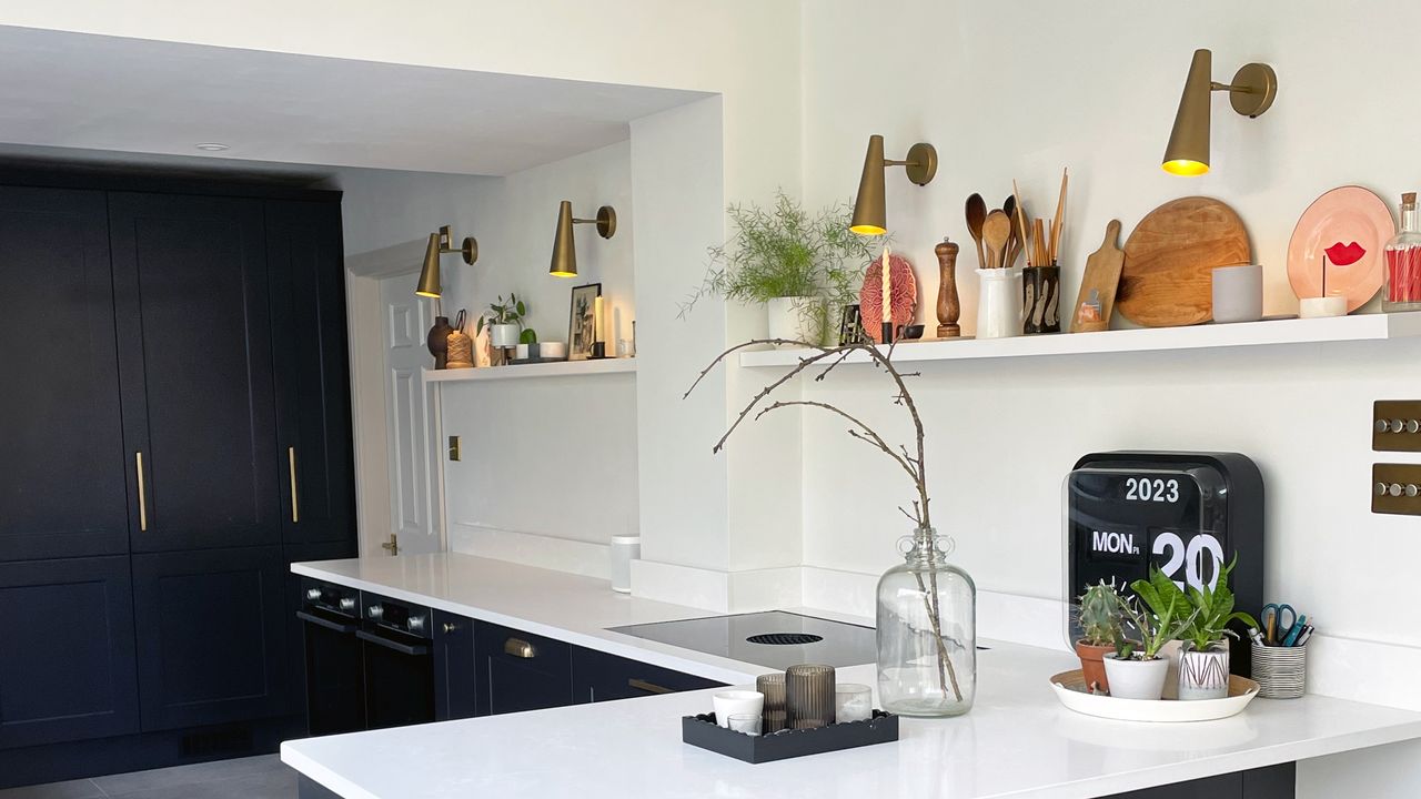 Charcoal grey kitchen with white worktops and upstands and an open shelf running along the wall