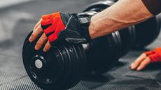 Best gym gloves: person moving dumbbells wearing gym gloves