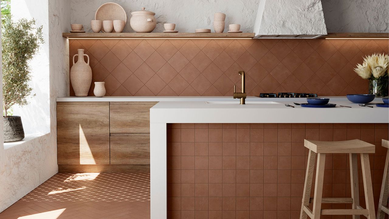 A kitchen with terracotta tiles on the floor, island and backsplash