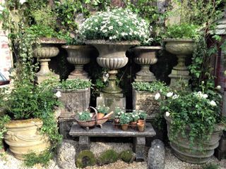 Aged stoneware planters in a rustic garden scheme