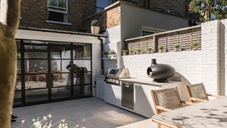 outdoor kitchen with black bbq and Belgian doors