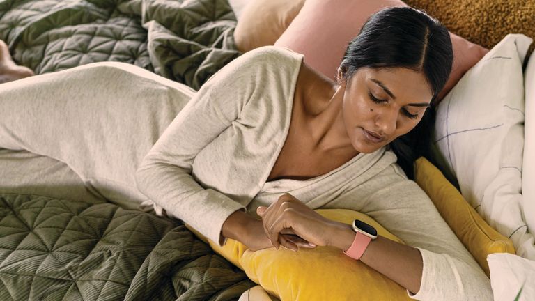 What is a Fitbit? Woman lying on bed with Fitbit 