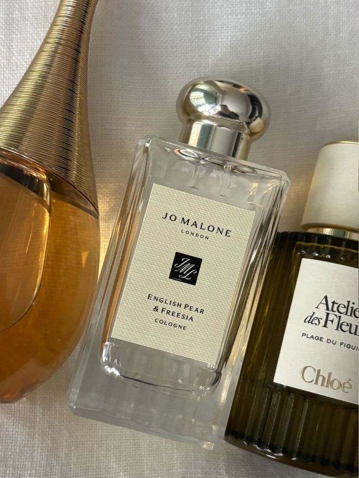 A selection of the best spring perfumes on a white linen background