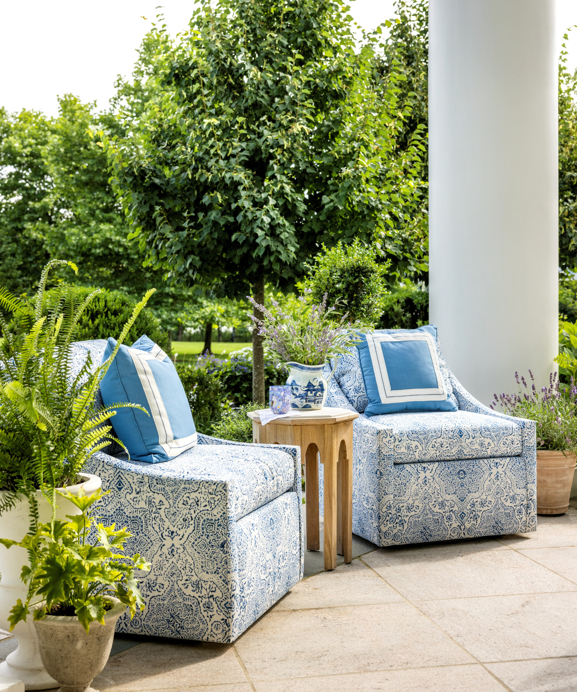 Colonial Revival back patio styled by Corey Damen Jenkins, featuring two patterned outdoor accent chairs styled with contrast-border throw pillows and a central accent table