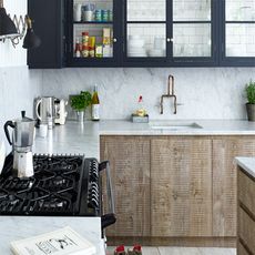 kitchen with white wall black storage unit wooden cabinet and white counter