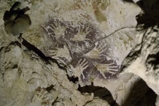 These mulberry-colored hands were painted over the older, reddish hand stencils found in the Indonesian cave. These two styles were created at least 20,000 years apart.