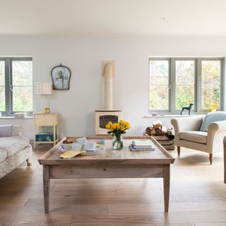 Light filled living room with log burner, large coffee table and wooden flooring in extended home