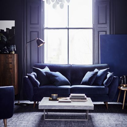 living room with velvet sofas with cushions and coffee table