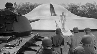 An alien stepping out of a ship with the military waiting during the Alien movie, The Day The Earth Stood Still.