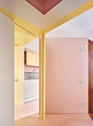 A passageway with pink doors and yellow walls