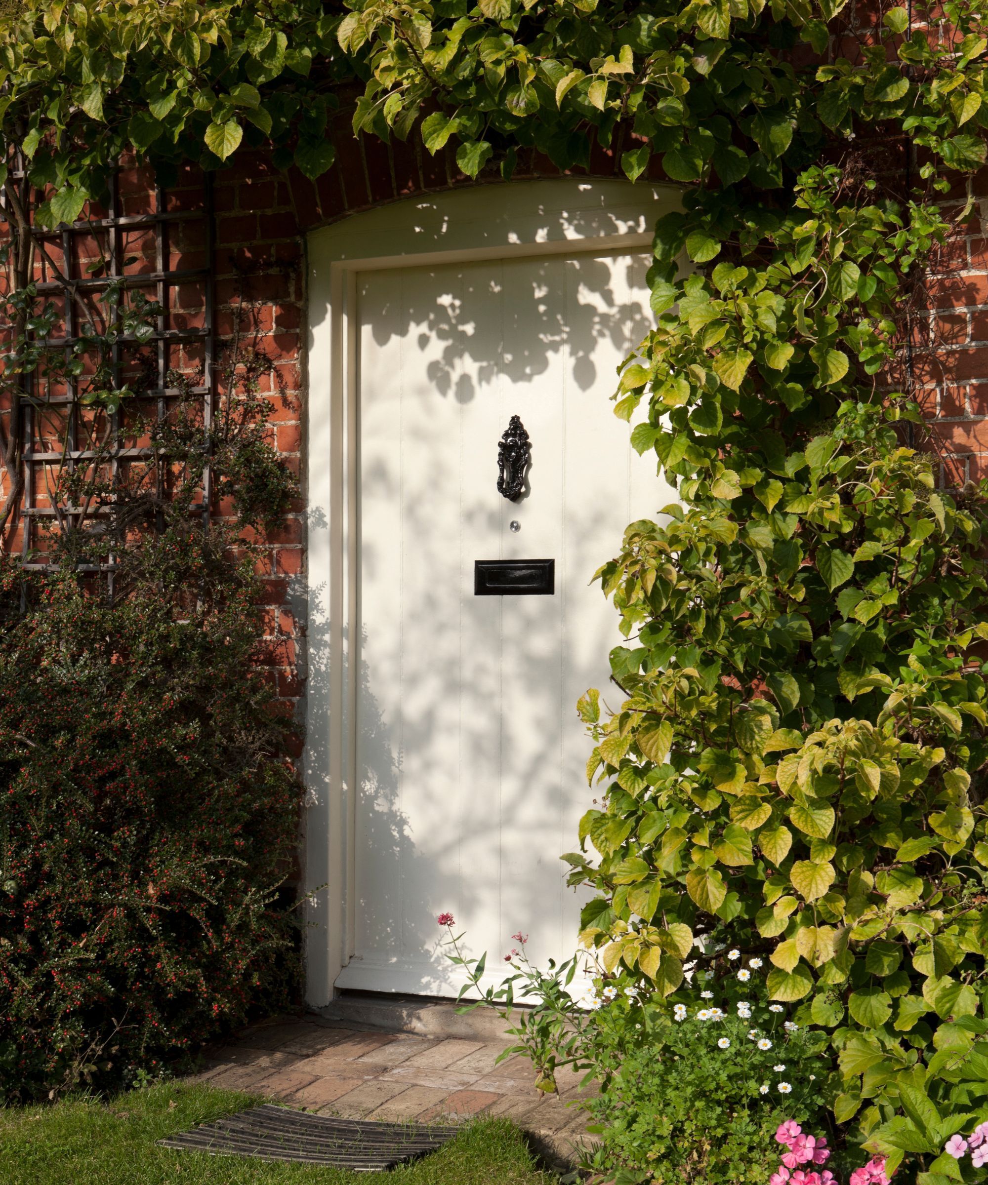 A red brick cottage with a white front door