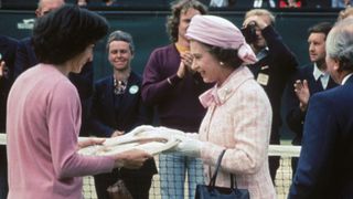 Queen Elizabeth II presents the trophy to British tennis player Virginia Wade after she won the Women's Singles competition at Wimbledon, 1st July 1977.