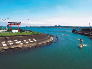 Picture of harbour next to island with green grass on.