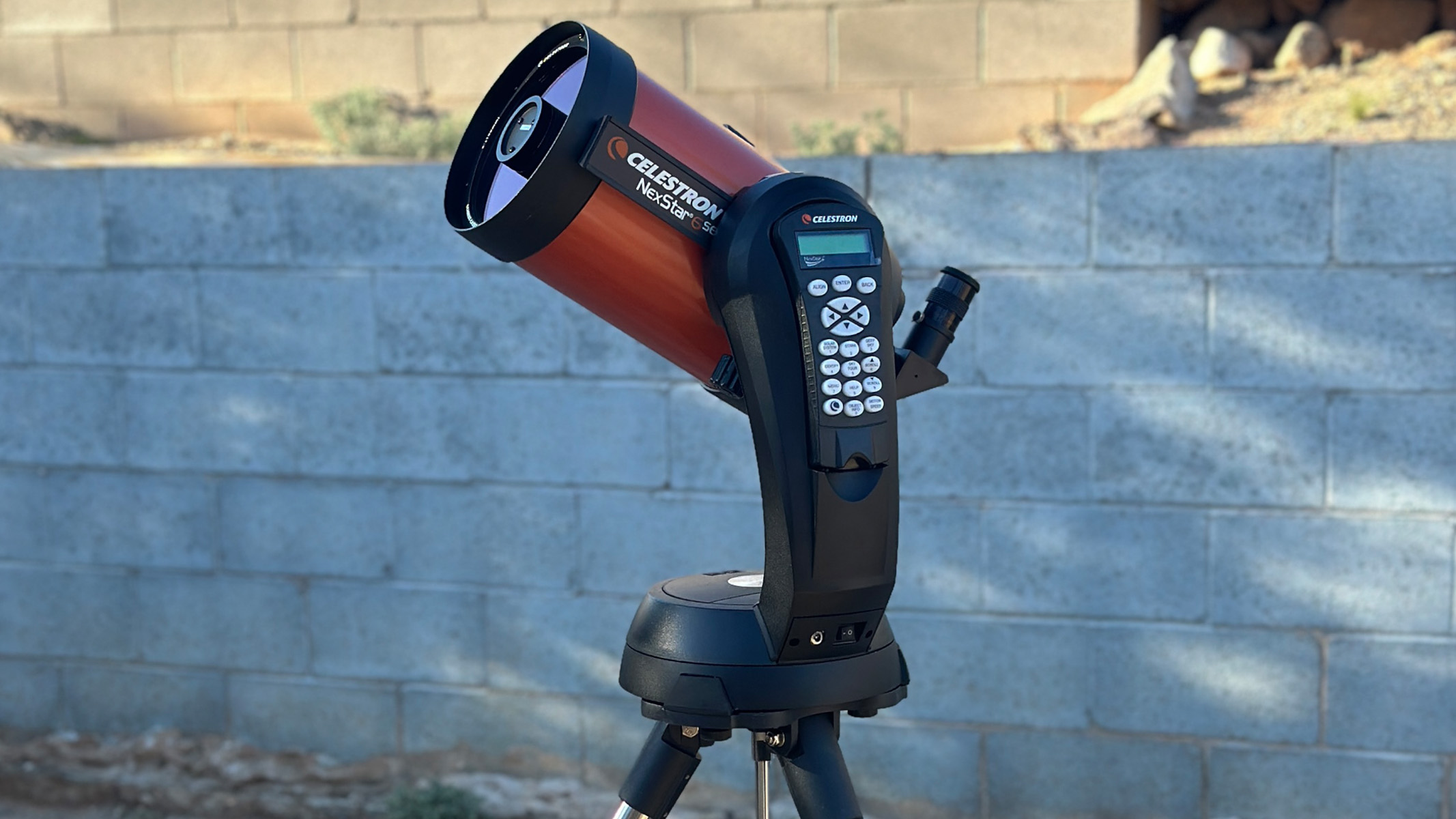 Celestron NexStar 6SE in a backyard, in front of a brick wall