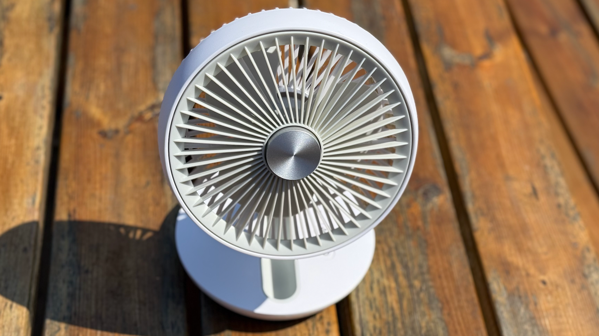 The Dimplex Rechargeable Cordless Desk Fan on a wooden bench table
