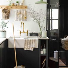 utility room colour ideas, black and white utility room with white marble worktop, Belfast sink, peg rail pale green pendant light, brass taps 