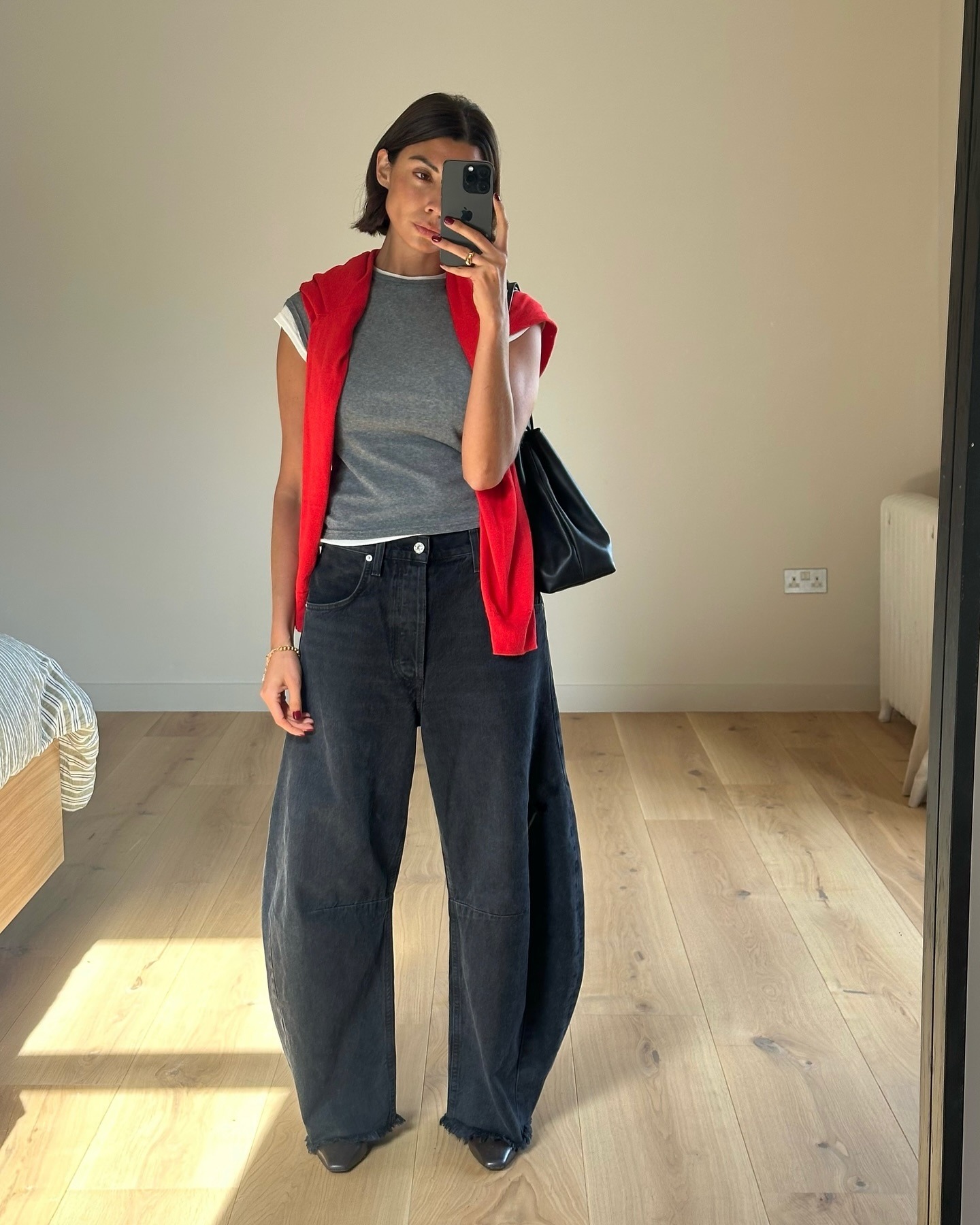 Influencer Marianne Smyth wears black barrel jeans with double tee shirts and red sweater.