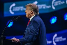 Donald Trump speaks at a lectern 