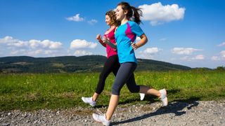 Two women power walking in active wear outdoors