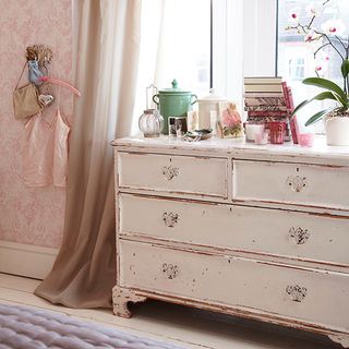 bedroom with wallpaper and drawer