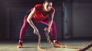 Five Ideas for Fun Cardio HIIT Workouts: woman working out with battle ropes