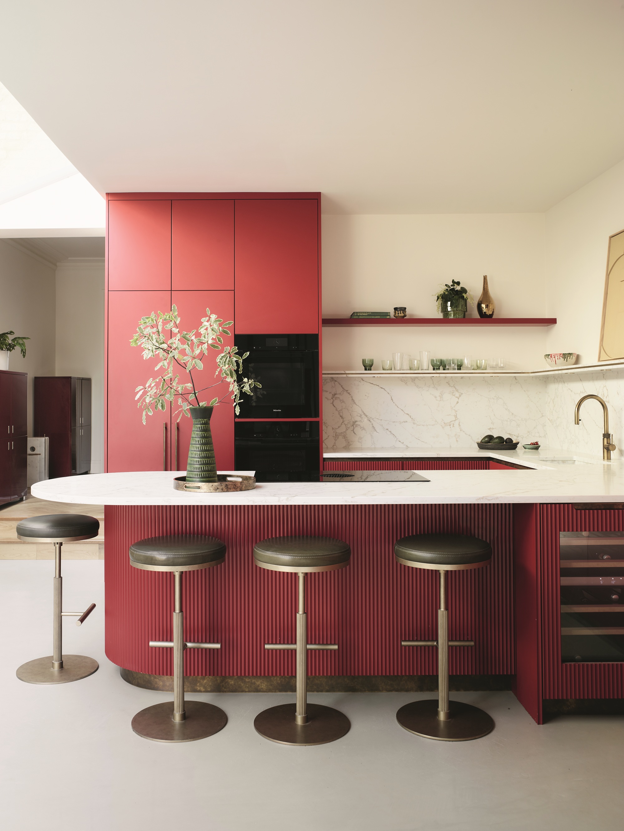 a red-pink kitchen with a reeded peninsula with a curved countertop