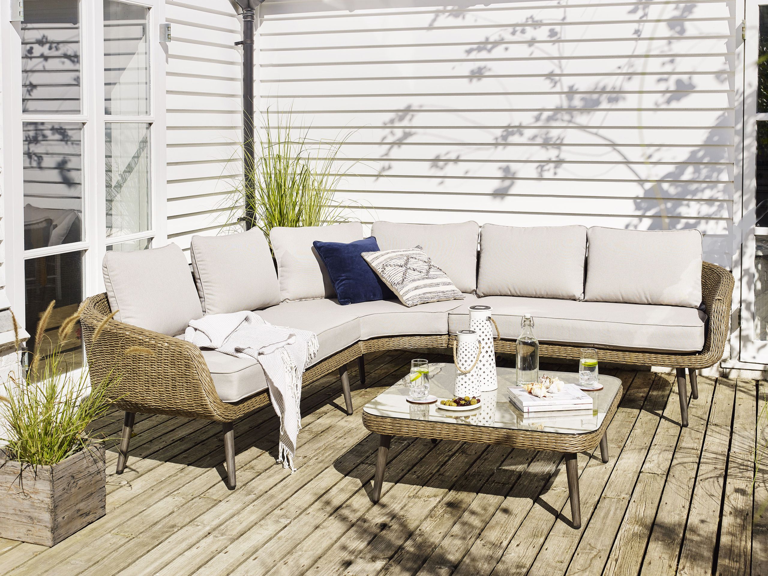 dækket terrasse med en hjørnesofa og matchende sofabord