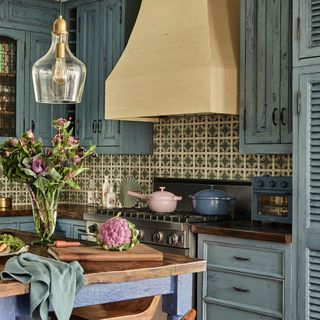 Our Place founder Shiza Shahid's blue kitchen in her Los Angeles home adorned with Spanish tiles and fitted with the Our Place Wonder Oven, Always Pan and Perfect Pots