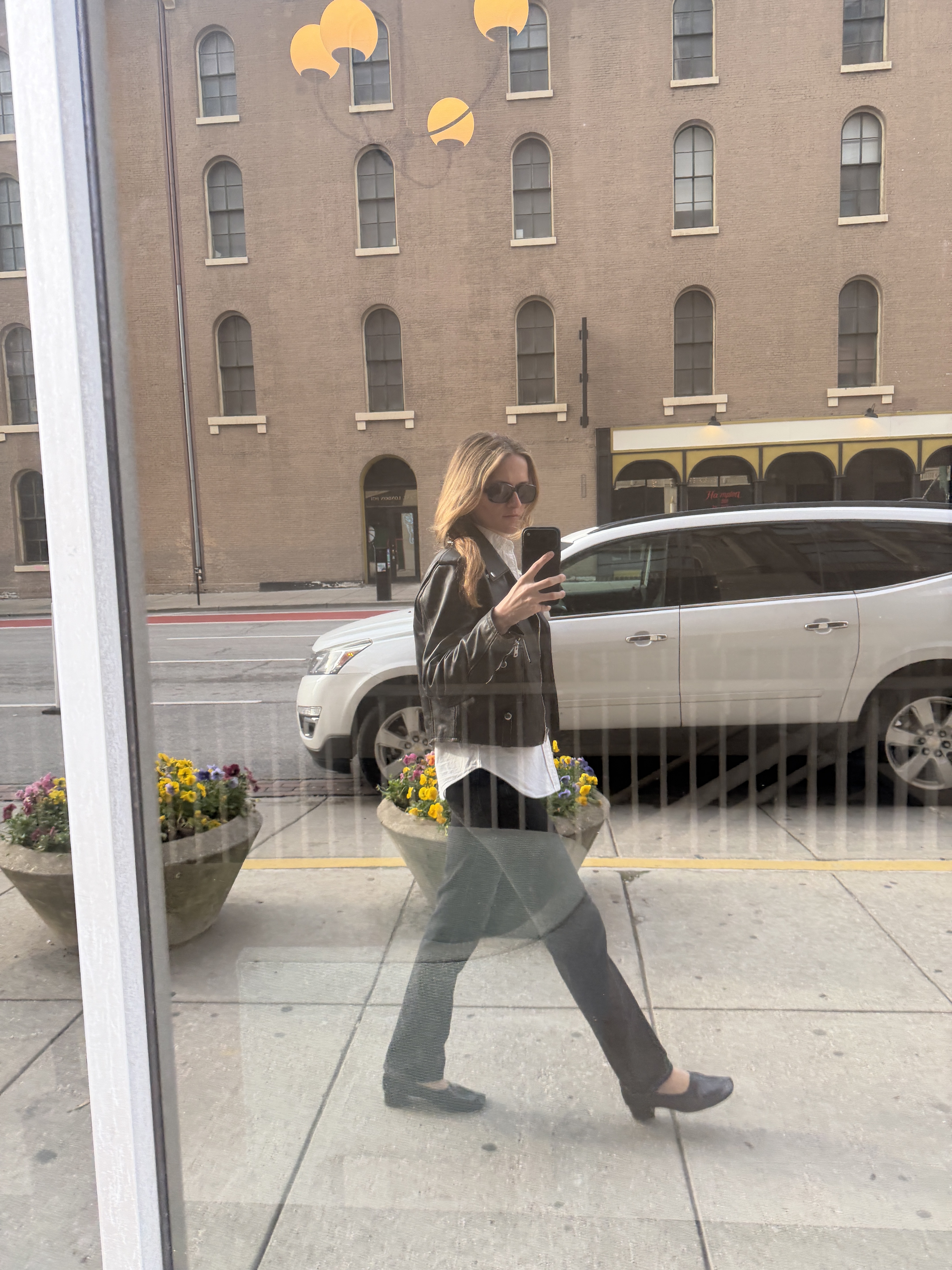 Eliza Huber wearing a leather jacket, white shirt, black jeans, and black shoes in Indianapolis.
