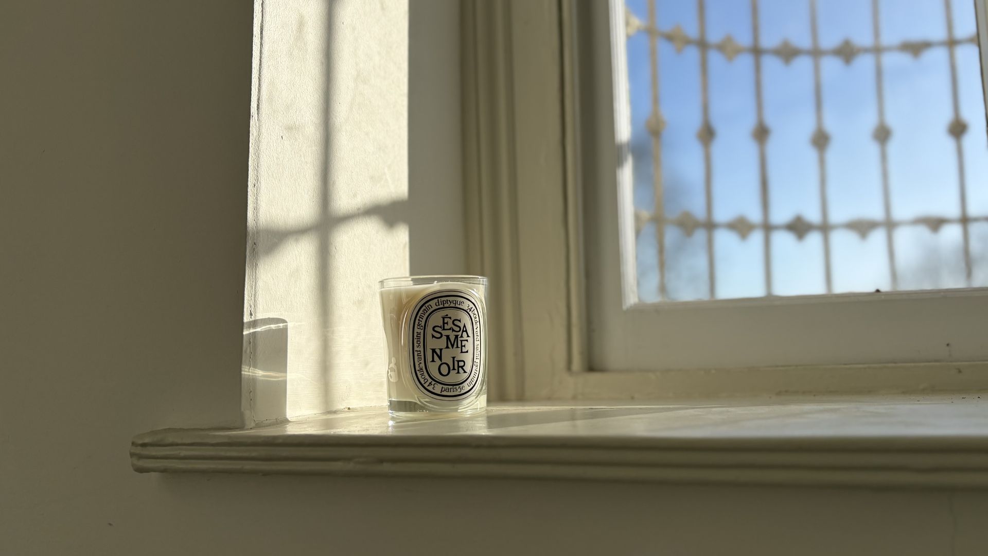 Diptyque Sesame Noir candle on a windowsil