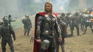 Chris Hemsworth's Thor holding Mjolnir on battlefield in Thor: The Dark World