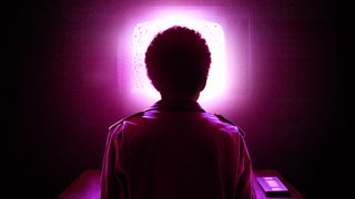 A boy sits in front of a glowing pink TV with a pink cassette next to them