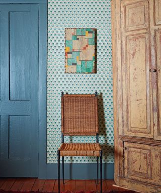 Blue wallpaper and door, wicker chair