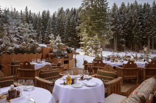 Outside dining terrace beside snow-covered piste at Loulou Courchevel