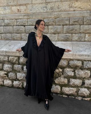 @annabelrosendahl wearing a flowy black maxi dress