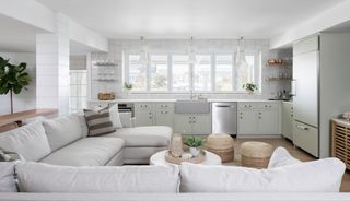 kitchen in sage green with living space and sofa