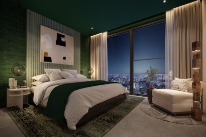 An image of a bedroom with floor to ceiling windows overlooking a city. 