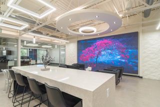 A nearly 16-foot-wide, 9-foot-high (8-by-8) Planar MGP Series LED video wall with a 1.2mm pixel pitch that is located in an “all-hands” meeting area.