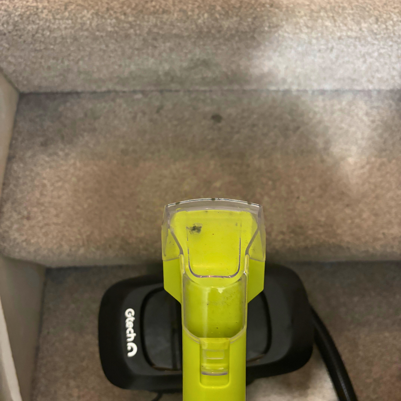 Gtech Koala Spot Cleaner placed on grey carpeted stairs